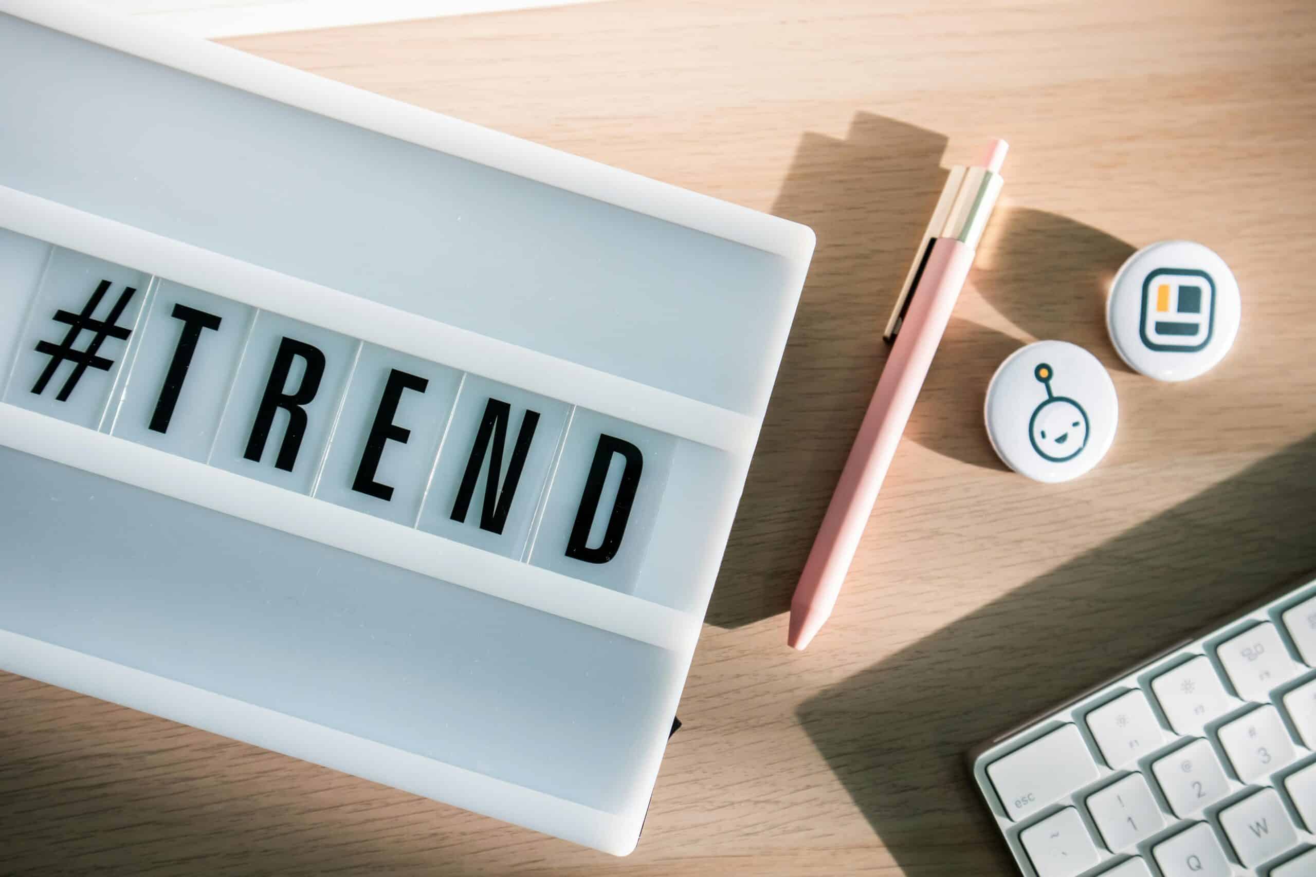 Affiche lumineuse "#TREND" avec stylos et accessoires de bureau modernes.